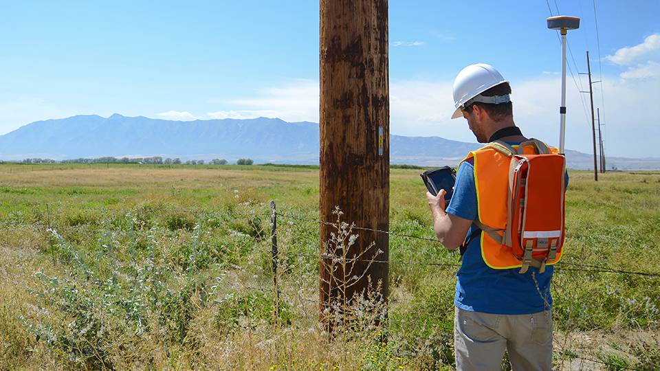 Man Inspecting and marking Utility Pole location using Mesa Geode and Uinta